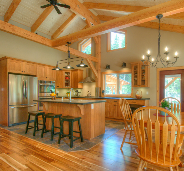 Open concept Kitchen with visible high ceiling rafters. One of our custom made timber frame home.